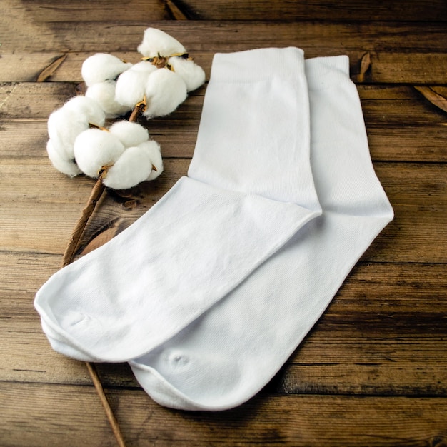 Des chaussettes blanches et du coton sont sur la table