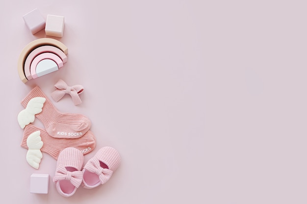Chaussettes, chaussures et jouets roses. Ensemble de trucs de bébé et d'accessoires pour fille sur fond pastel. Notion de douche de bébé. Nouveau-né de mode. Mise à plat, vue de dessus
