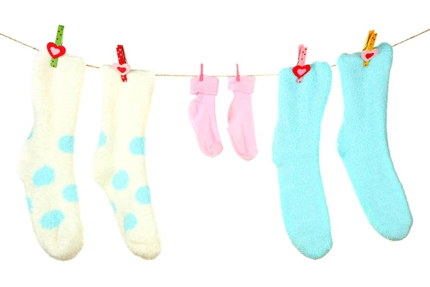 Chaussettes colorées accrochées à une corde à linge isolées sur blanc