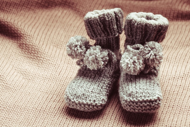 Chaussons bébé en laine tricotée avec pompons close up