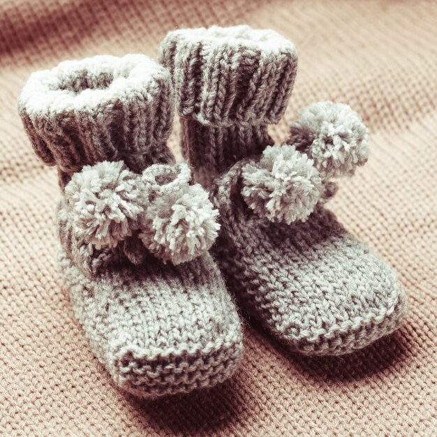 Chaussons bébé en laine tricotée avec pompons close up