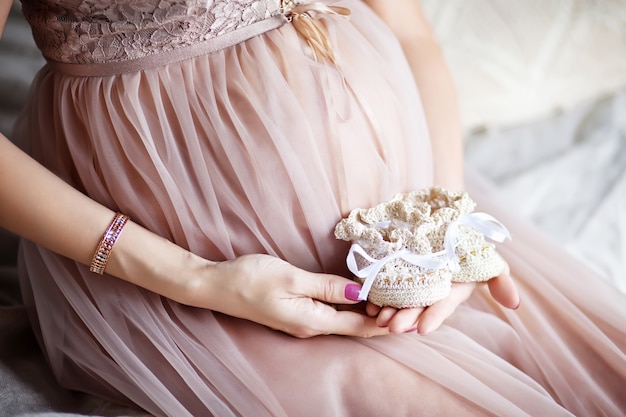 Chaussons de bébé nouveau-né dans les mains des mères