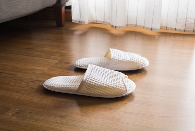 Chaussons blancs sur plancher en bois