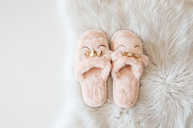 Chaussons de maison sur un tapis moelleux blanc