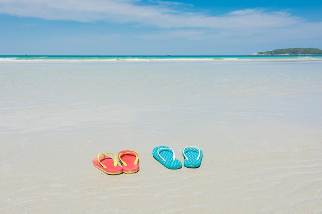 Chaussons de plage sur la plage tropicale