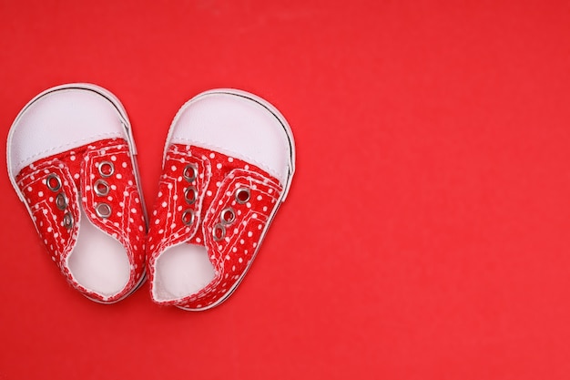 Chaussons rouges à pois blancs sur fond rouge