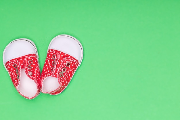 Chaussons rouges à pois blancs sur fond vert