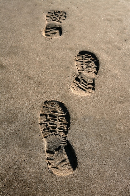 Photo chaussure empreinte sur fond de sable plage brun