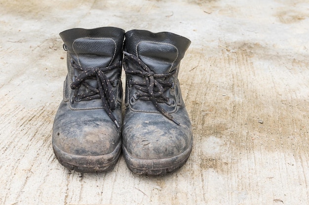 Photo chaussure d'homme en cuir de sécurité sur le fond de texture du sol en ciment