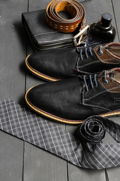 Chaussures et accessoires pour hommes étendus sur le plancher en bois