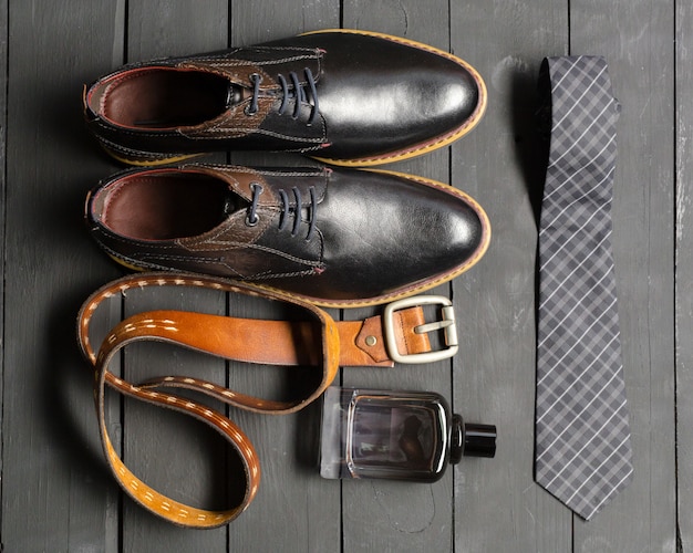 Chaussures et accessoires pour hommes étendus sur le plancher de bois