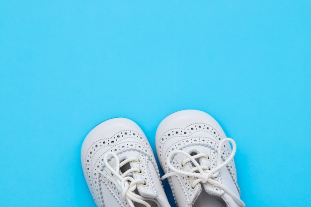 Chaussures bébé blanc sur fond bleu