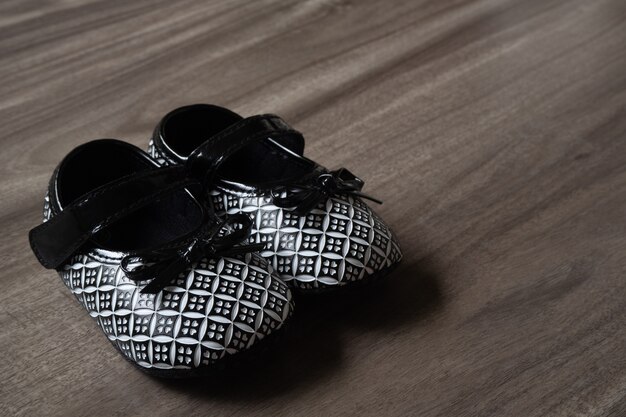 Chaussures de bébé Little Baby noir et blanc sur fond de bois