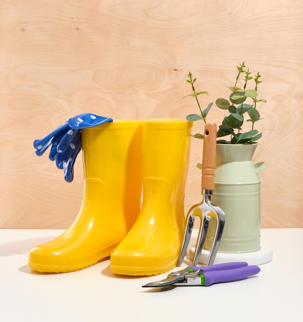 Chaussures en caoutchouc jaune brillant pour les travaux de jardinage Gants en cautchouc bleus avec points blancs Secateur et autres accessoires pour le travail