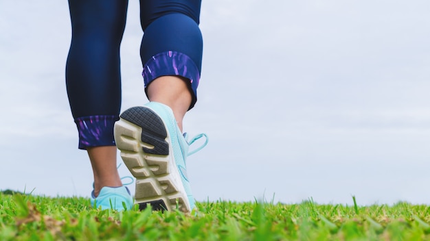 Chaussures de course fitness femme athlète en se promenant dans le parc en plein air.