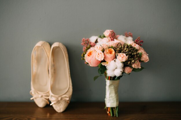 Chaussures crème de la mariée sur le vert sur une table en bois