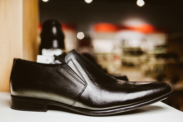 Chaussures en cuir élégantes pour hommes sur l'étagère du magasin de traitement de photos vintage