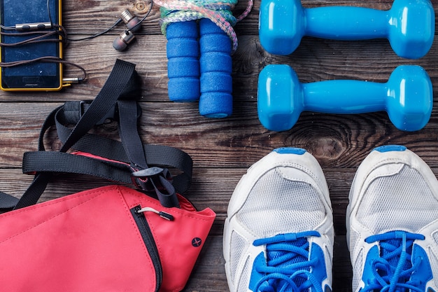 Chaussures et équipement de sport sur la vue de dessus de plancher en bois