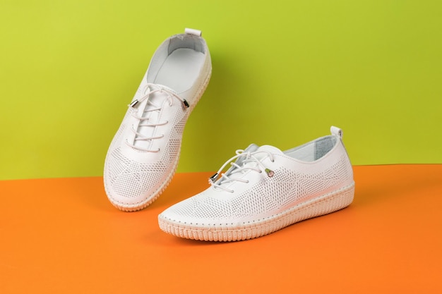 Chaussures d'été en cuir blanc sur fond orange et vert