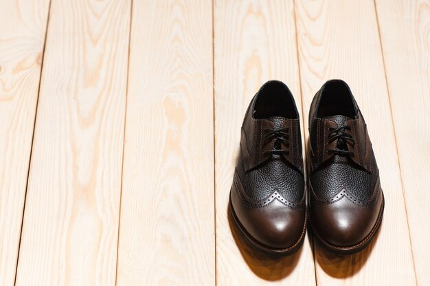 Chaussures homme en cuir plancher en bois clair.