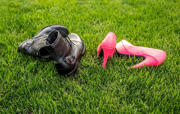 Chaussures d'un homme et d'une femme sur l'herbe verte Concept de vacances d'été