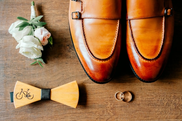 Les chaussures des hommes élégants sur une table en bois sombre à côté des chaussures est un, le marié est prêt pour le mariage