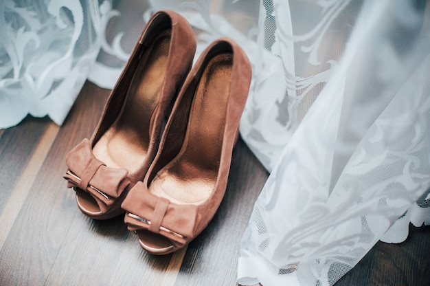 Chaussures de mariée marron sur un plancher en bois