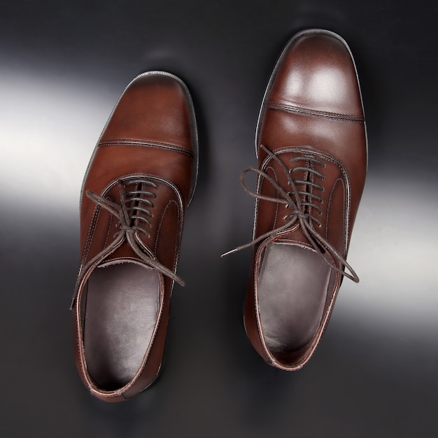 Chaussures marron pour hommes classiques sur sol sombre