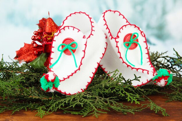 Chaussures de Noël avec des décorations sur table sur fond clair