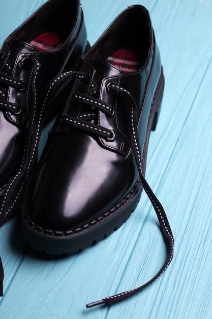 Chaussures noires élégantes sur fond bleu. tendances de la mode. belles chaussures pour femmes