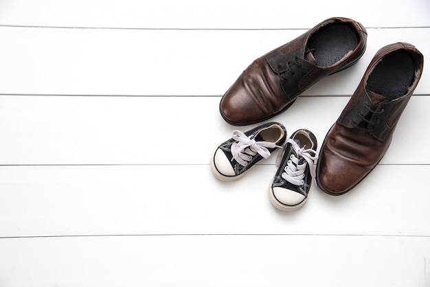 Les chaussures de père et fils sur fond blanc bois - concept attention