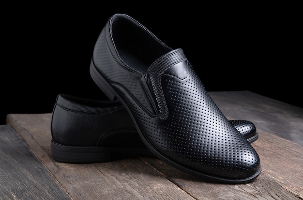 Chaussures pour hommes noirs sur table en bois