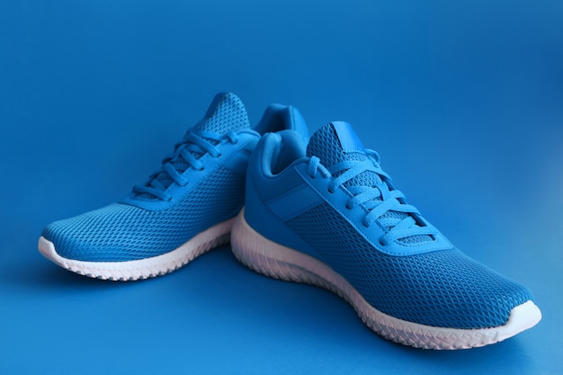 Chaussures de sport colorées sur mur de couleur bleue