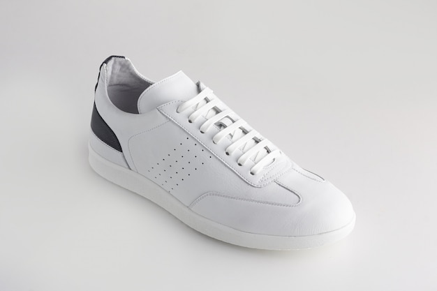 Chaussures de sport en cuir blanc idolâtrées sur fond blanc.