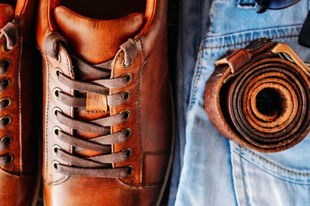 Chaussures de sport en cuir marron, jeans et vue de dessus de ceinture se bouchent. Concept de mode