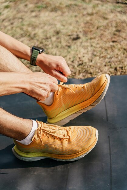 Photo chaussures de sport pour courir jaune break l'homme sur le tapis ajuste ses baskets concept de remise en forme