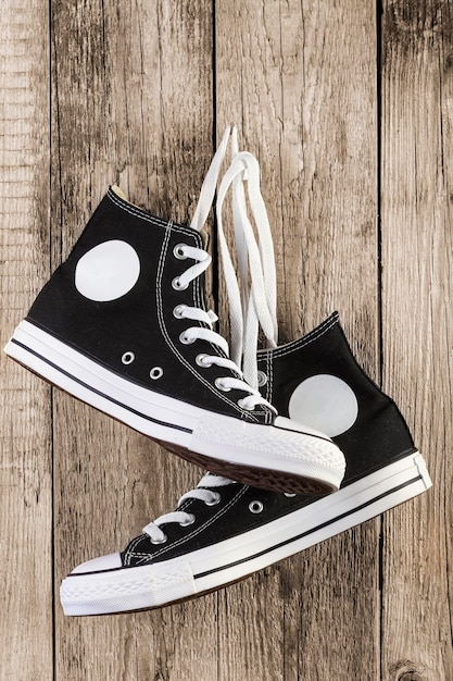 Photo des chaussures en toile accrochées au mur en bois