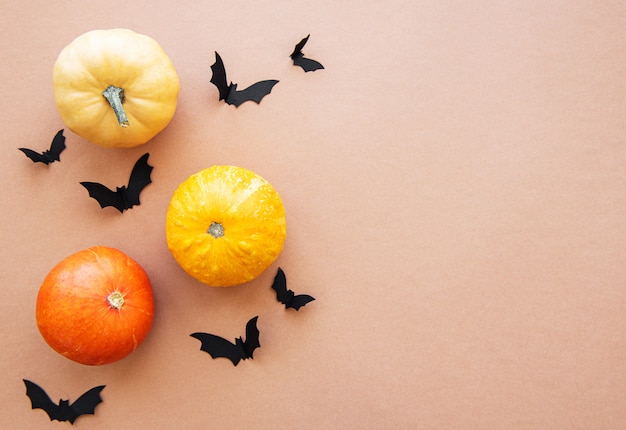 Chauves-souris d'Halloween et citrouilles sur fond marron