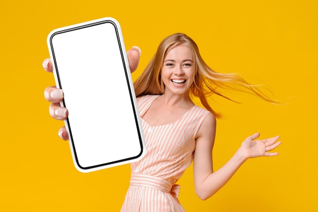 Cheerful Blonde Lady montrant Smartphone avec écran vide