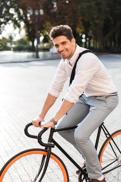 Cheerful businessman habillé en chemise à vélo