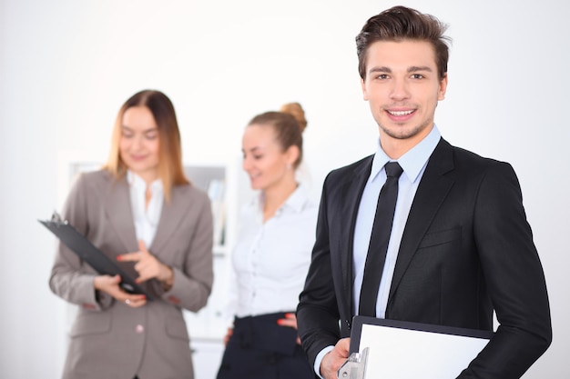 Cheerful businessman in office avec des collègues en arrière-plan