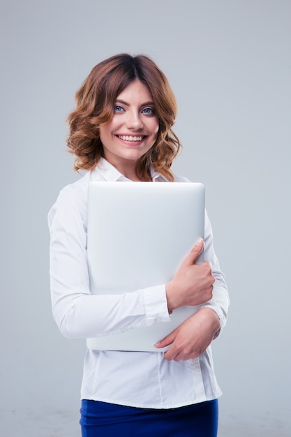 Cheerful businesswoman debout avec ordinateur portable