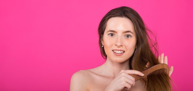 Cheerful cheery lady holding in hand comb fermeture visage lisse doux effet cheveux soyeux kératine