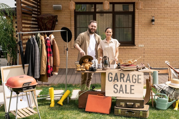 Cheerful couple hébergeant la vente de garage