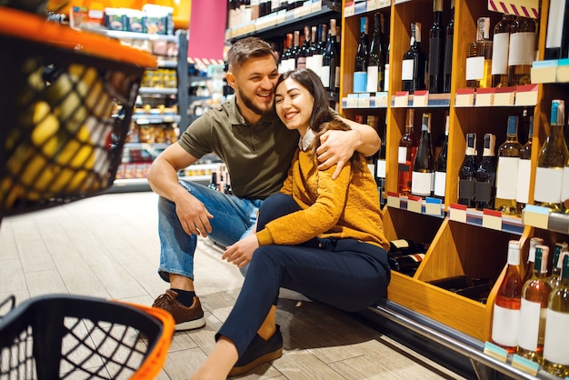 Cheerful couple with cart in épicerie supermarché ensemble