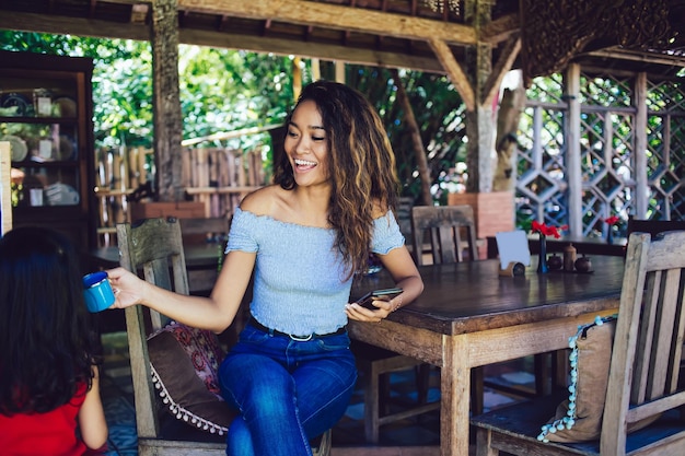 Cheerful female sitting in cafe avec petite fille