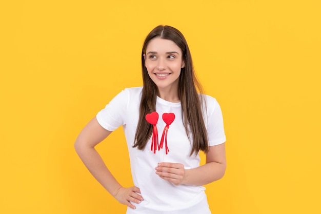 Cheerful girl tenir coeur en chemise blanche sur fond jaune saint valentin