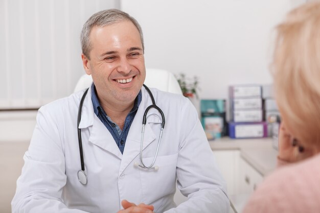 Cheerful male male doctor parler à un patient