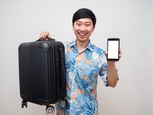 Cheerful man beach shirt hold laggage show mobile phone for booking with holiday