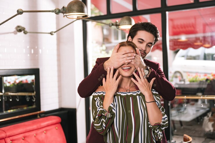 Photo cheerful mature woman rire et homme couvrant ses yeux